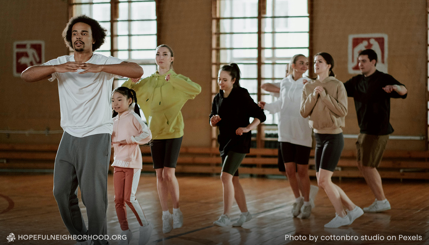 A multicultural community group learning to dance in a large room